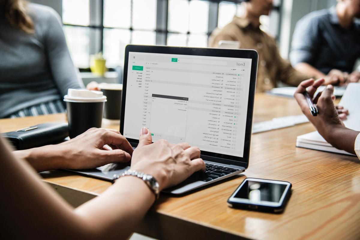 Person at table looking at email on laptop