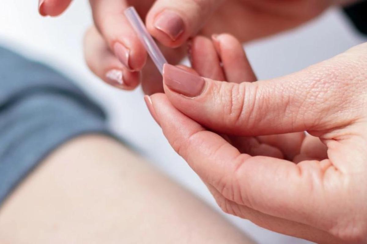 Hand holding a needle in a case